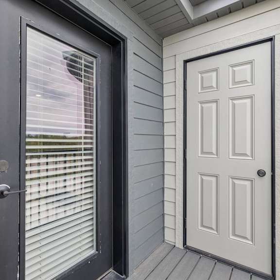 Thumbnail 39 of 39 Apartment balcony with private storage closet, gray siding, and wood-look decking.