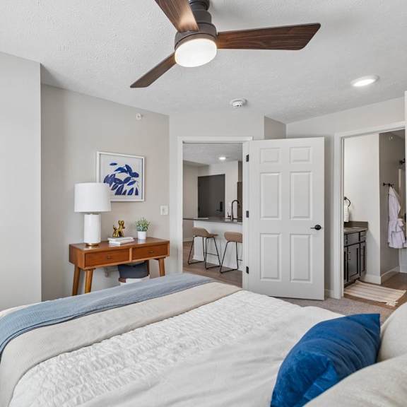 Thumbnail 33 of 39 Apartment bedroom with ceiling fan, full-length mirror, and neutral finishes.