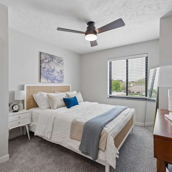 Thumbnail 32 of 39 Bright apartment bedroom with ceiling fan and large window.