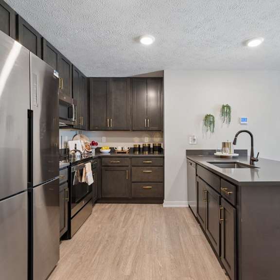 Thumbnail 27 of 39 Modern apartment kitchen with island and stainless steel appliances.