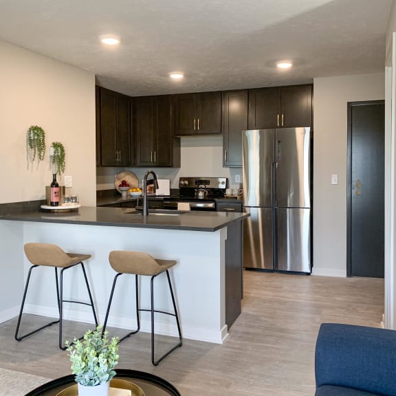 Thumbnail 8 of 24 a kitchen with a large island with two stools in front of it