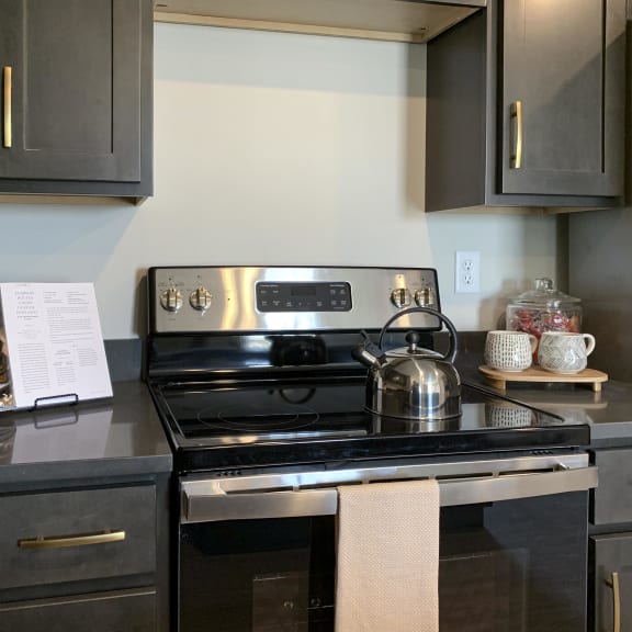 Thumbnail 5 of 24 a kitchen with black cabinets and stainless steel appliances