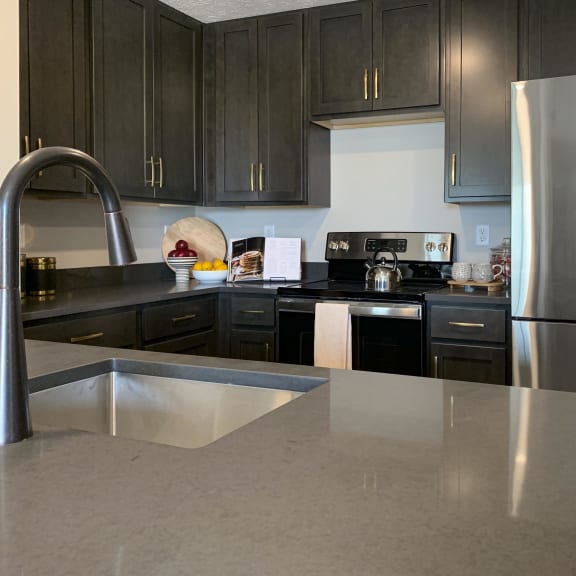 Thumbnail 2 of 24 a kitchen with dark cabinets and a large island