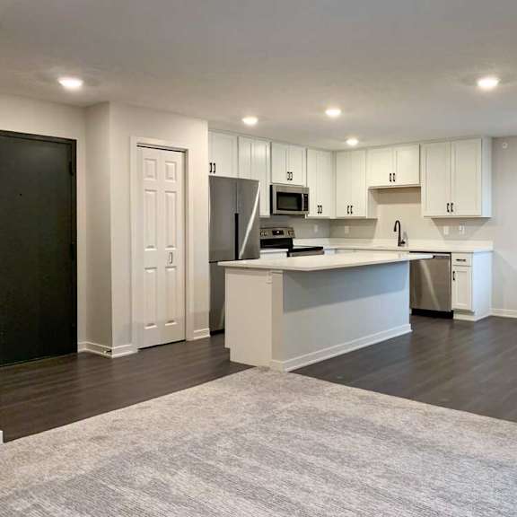 Thumbnail 3 of 29 modern kitchen with white cabinets and a island with wood look flooring and carpet