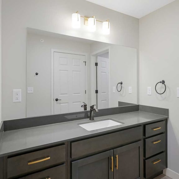 Thumbnail 26 of 29 a bathroom with a wide vanity sink and mirror