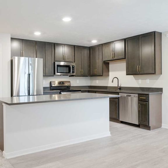 Thumbnail 5 of 29 a kitchen with a large island and dark cabinets