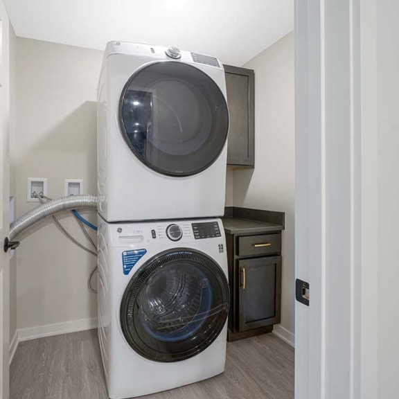 Thumbnail 16 of 29 a stacked washer and dryer in the laundry room and coat closet