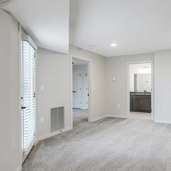 Thumbnail 21 of 29 a living room with doors to the bathroom and bedroom spaces