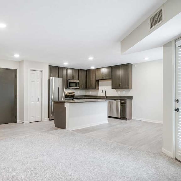 Thumbnail 8 of 29 a living room and a kitchen with dark cabinets