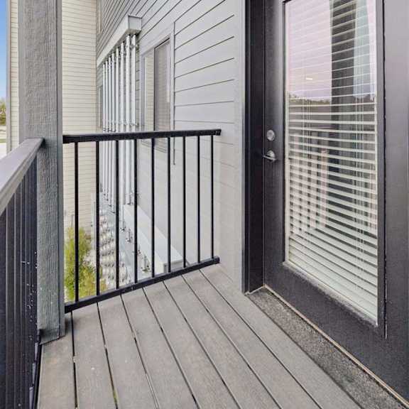 Thumbnail 36 of 36 Apartment balcony with privacy railing, gray siding, and glass patio door.