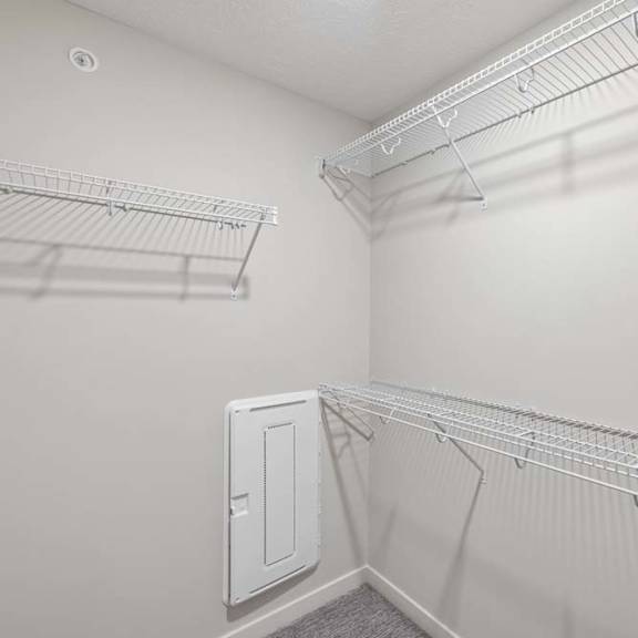 Thumbnail 29 of 36 Walk-in closet with built-in wire shelving, hanging space, and attic access panel.