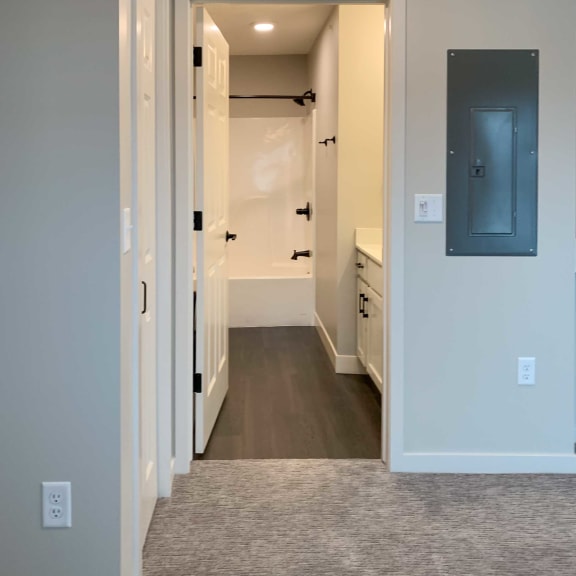 Thumbnail 11 of 15 a bathroom with white cabinets and hardwood floors
