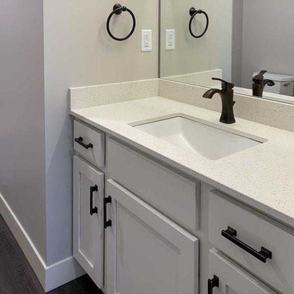 Thumbnail 13 of 15 a bathroom with white cabinets and granite countertops