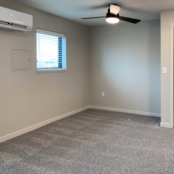 Thumbnail 9 of 15 a carpeted room with a ceiling fan and a window