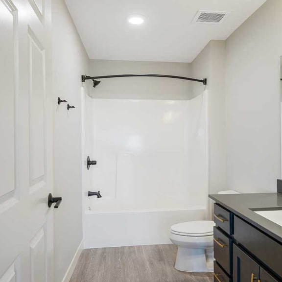 Thumbnail 19 of 19 A white modern bathroom with a shower and a sink and a toilet