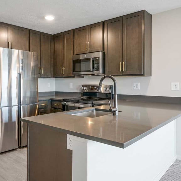 Thumbnail 3 of 19 A kitchen with a large countertop and stainless steel appliances