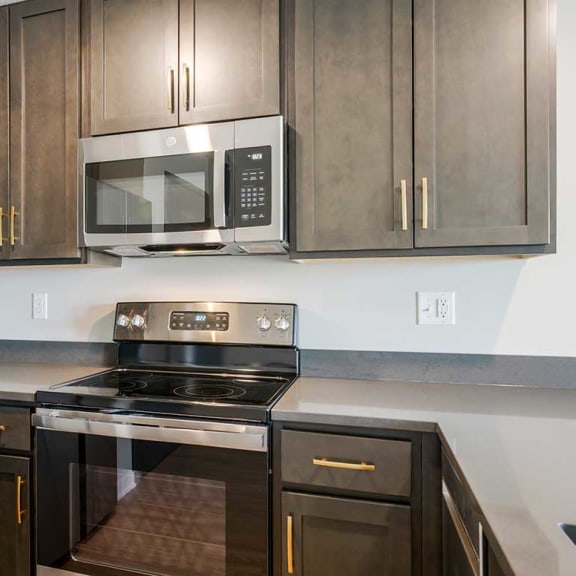 Thumbnail 5 of 19 A u-shaped kitchen with dark cabinets and stainless steel appliances