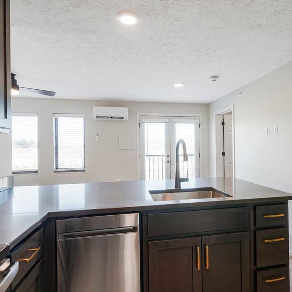 Thumbnail 9 of 19 A kitchen peninsula with a drop-in sink and dark cabinets