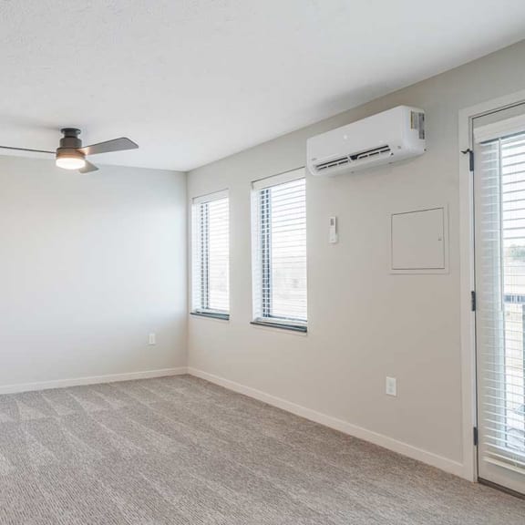 Thumbnail 14 of 19 A carpeted room with windows and a ceiling fan