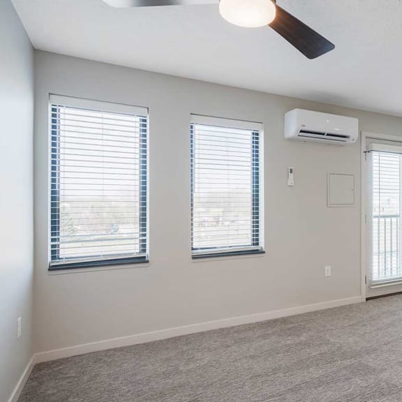 Thumbnail 13 of 19 A room with a ceiling A/C unit, a fan, several windows, and a Juliet balcony