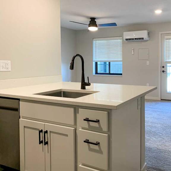 Thumbnail 20 of 25 a kitchen peninsula with white quartz countertops and white cabinets