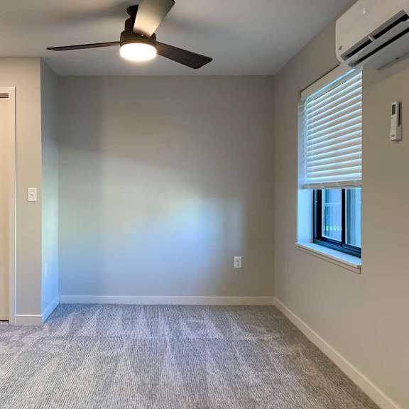 Thumbnail 22 of 25 a living room with a ceiling fan, a closet, and a window with blinds