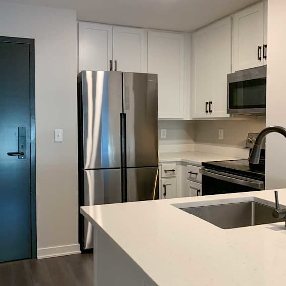 Thumbnail 19 of 25 a modern kitchen with white cabinets, quartz countertops, and stainless steel appliances