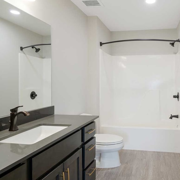 Thumbnail 15 of 17 a bathroom with a vanity sink, toilet, and a shower