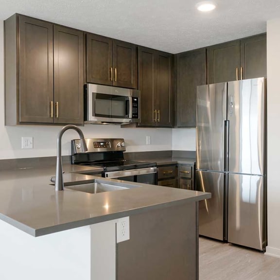 Thumbnail 5 of 17 a kitchen with stainless steel appliances and dark stone counter top