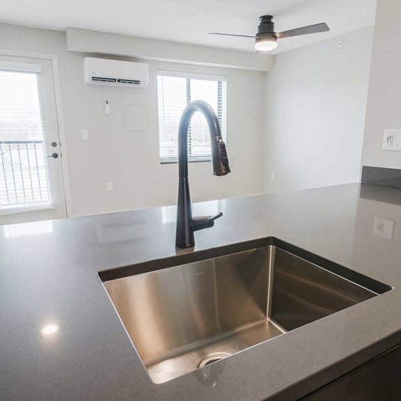 Thumbnail 7 of 17 a kitchen with a drop-in sink and a gooseneck faucet