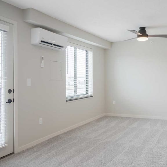 Thumbnail 12 of 17 the main room with a ceiling fan, wall-mounted A/C, and large window