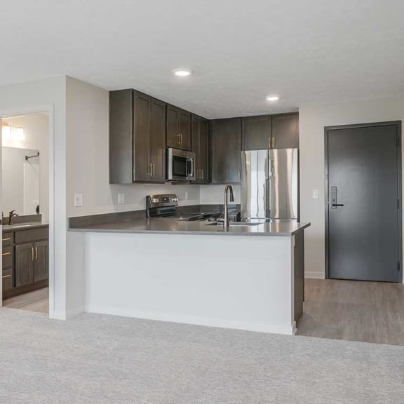 Thumbnail 2 of 17 a look at the kitchen with dark cabinets and stainless steel appliances from the main room