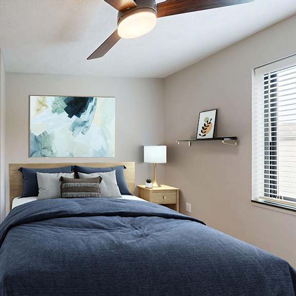 Thumbnail 24 of 30 A bedroom with a bed, a ceiling fan, and a painting on the wall.