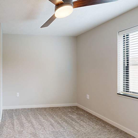 Thumbnail 23 of 30 A room with bifold closet doors and a ceiling fan.