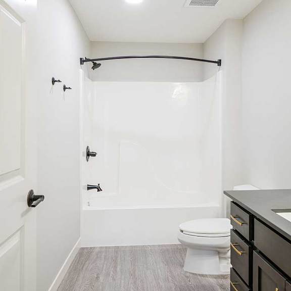 Thumbnail 28 of 30 The primary attached bathroom featuring a tub shower with modern dark finishes