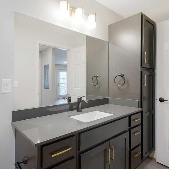 Thumbnail 19 of 30 The hallway bath featuring a large vanity sink with tall cabinet storage on the right side