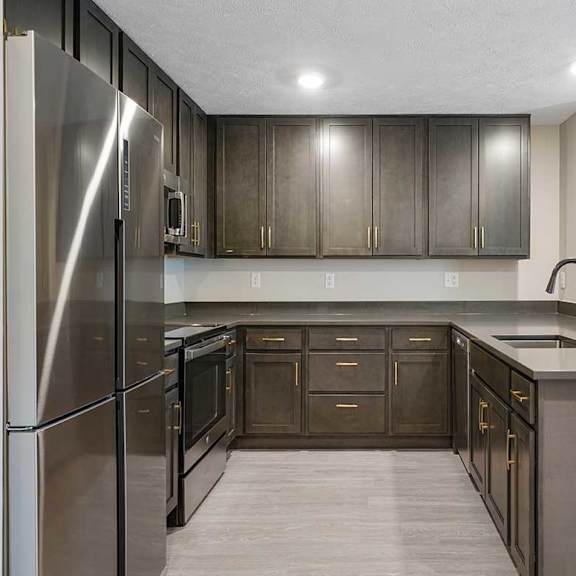 Thumbnail 3 of 30 A U-shaped kitchen featuring dark cabinets and stainless steel appliances