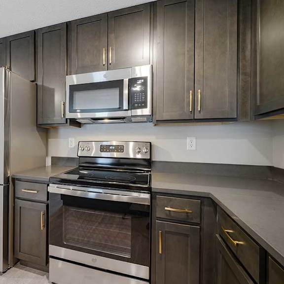 Thumbnail 4 of 30 A U-shape kitchen featuring dark cabinets and stainless steel appliances