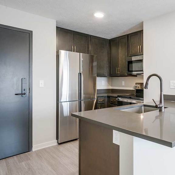 Thumbnail 7 of 25 a kitchen with dark cabinets and stainless steel appliances