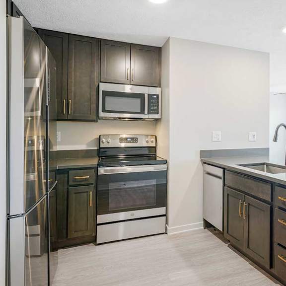 Thumbnail 3 of 25 a kitchen with stainless steel appliances and dark wooden cabinets