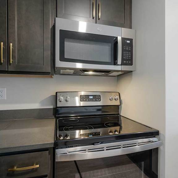 Thumbnail 4 of 25 a kitchen with a stainless steel microwave and glass stovetop