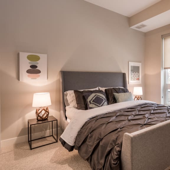 Thumbnail 11 of 18 bedroom with large window, queen sized bed, and nightstands with lit lamps
