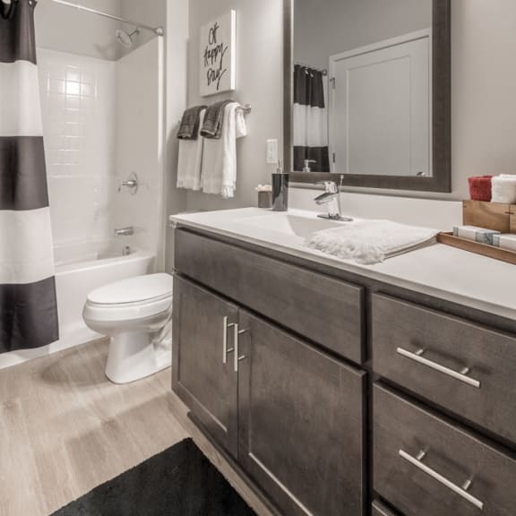 Thumbnail 13 of 13 Bathroom with dark cabinets and white, cultured-marble countertops at The Preserve at Normandale Lake