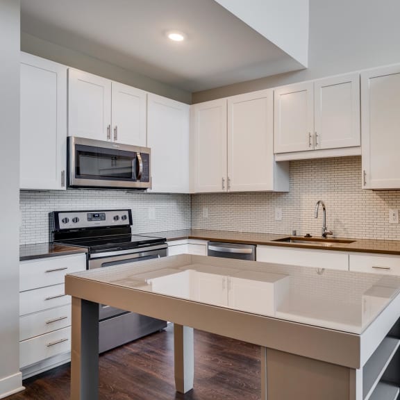Thumbnail 5 of 18 The Harriet features modern white cabinets, stainless appliances,  and a movable kitchen island