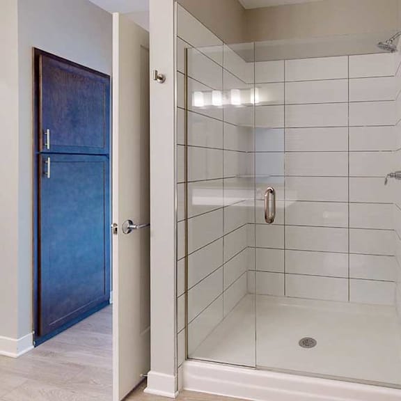 Thumbnail 18 of 22 A bathroom with a tiled walk-in shower with a glass door.