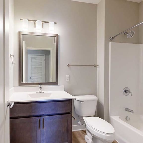 Thumbnail 22 of 22 A bathroom with a marble vanity, dark wooden cabinets, and a tub shower.