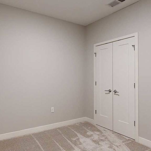 Thumbnail 20 of 22 A carpeted den space with a double-door closet.