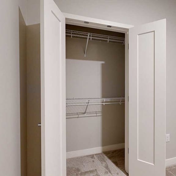 Thumbnail 21 of 22 A den space with a double-door closet with built-in wire shelves.