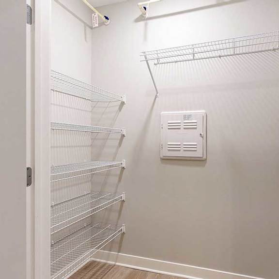 Thumbnail 8 of 22 A hallway closet with several built-in wire shelves.