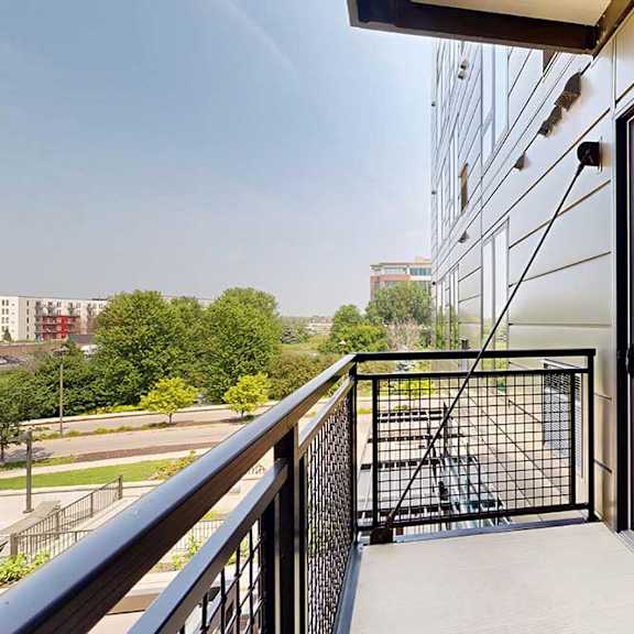 Thumbnail 10 of 25 A balcony with a metal railing and a view of the neighborhood.